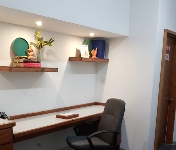 Consultorio de Clínica Delta con escritorio y repisas